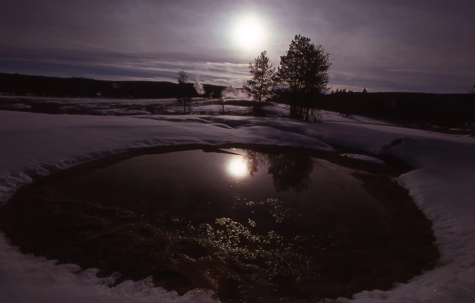 Hot spring & Castle Geyser surrounded by snow in winter