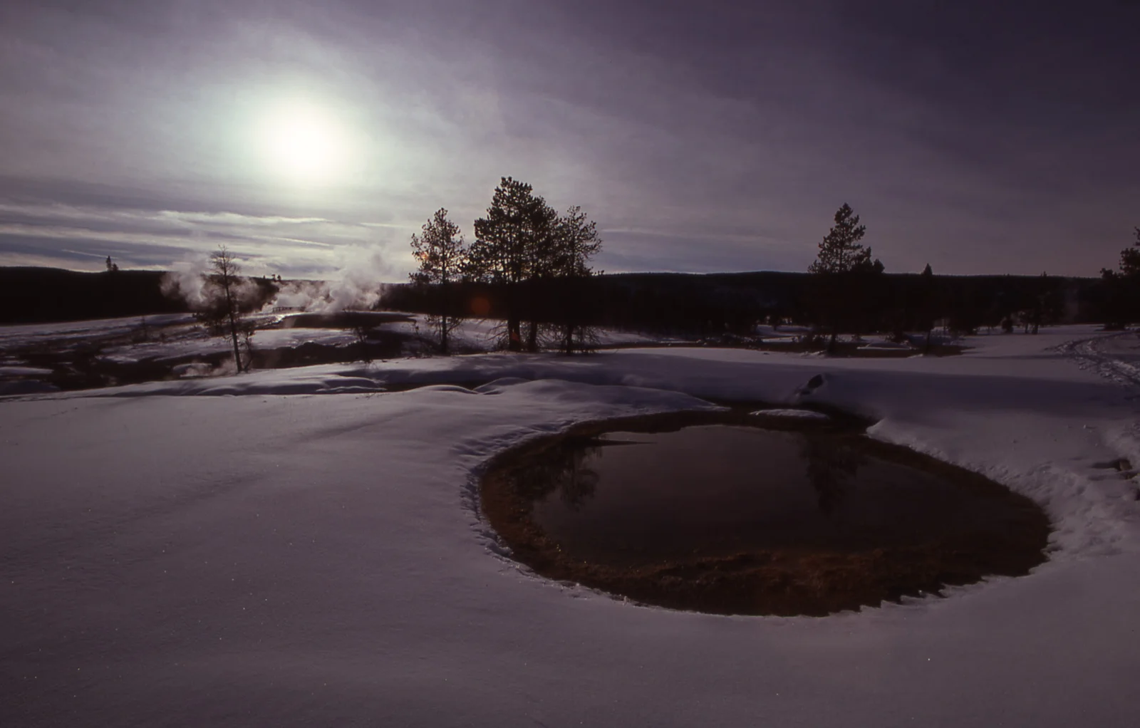Hot spring & Castle Geyser surrounded by snow in winter